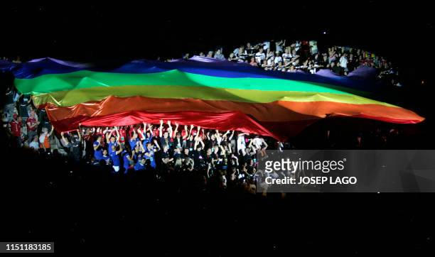 Participants hold up a gay and lesbian flag during the innaugural ceremony of the Eurogames 2008 at the Palau Sant Jordi indoor sporting arena in...