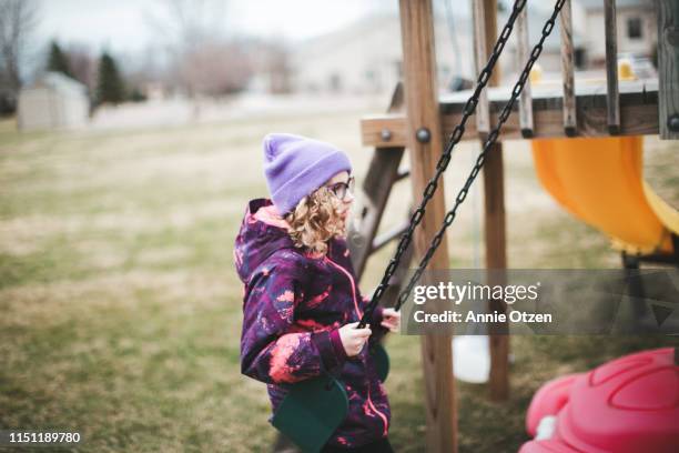 girl playing on backyard swing set - backyard swing set stock pictures, royalty-free photos & images