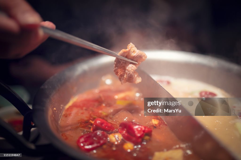 Heiße Topfmahlzeit. Die Nahrung mit Stäbchen.