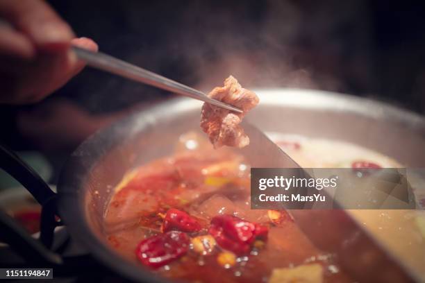 hot pot meal. hands taking food with chopsticks. - hot pots stock pictures, royalty-free photos & images