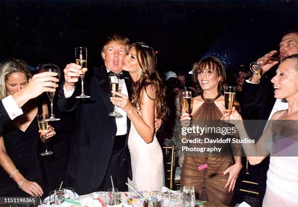 Along with unidentified others, American real estate developer Donald Trump and his girlfriend, model Melania Knauss , raise their glasses for a New...