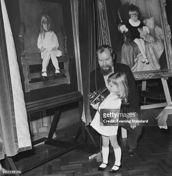 English pop artist Peter Blake with 3-years-old 'Miss Pears' Justine Hornby, holding a medium format camera, at the Painters Hall, London, UK, 3rd...