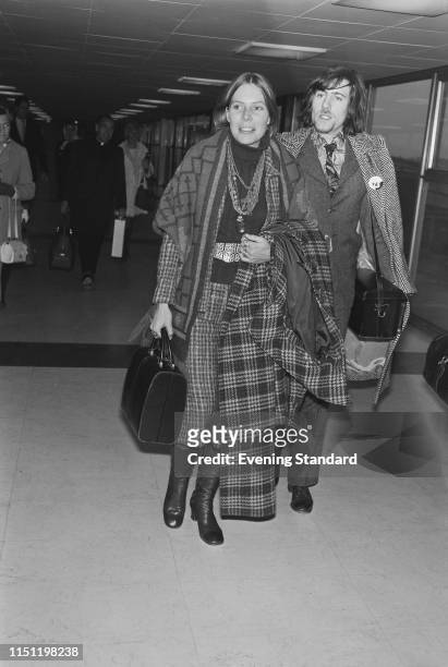 Canadian singer-songwriter Joni Mitchell with English singer-songwriter and musician Graham Nash at Heathrow Airport, London, UK, 30th December 1969.