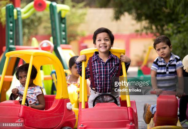 children having fun playing on toy rides - playing stock pictures, royalty-free photos & images