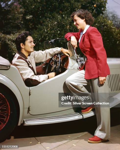 American actor John Derek with his wife, actress and ballet dancer Pati Behrs at the wheel of his MG TC Roadster, circa 1950.