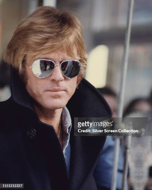 American actor Robert Redford wearing mirrored Ray-Ban aviator sunglasses in the film 'Three Days of the Condor', 1975.