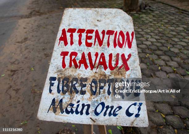 Warning billboard in the street about a construction site for internet optic fiber, Sud-Comoé, Grand-Bassam, Ivory Coast on May 10, 2019 in...