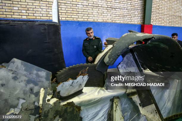 General Amir Ali Hajizadeh , Iran's Head of the Revolutionary Guard's aerospace division, looks at debris from a downed US drone reportedly recovered...