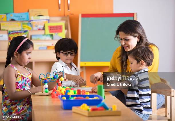 teachers with children learning at preschool - children stock pictures, royalty-free photos & images
