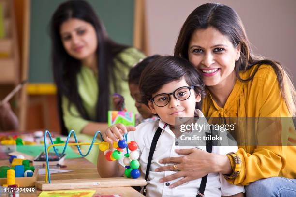 teacher embracing preschool boy - preschool stock pictures, royalty-free photos & images