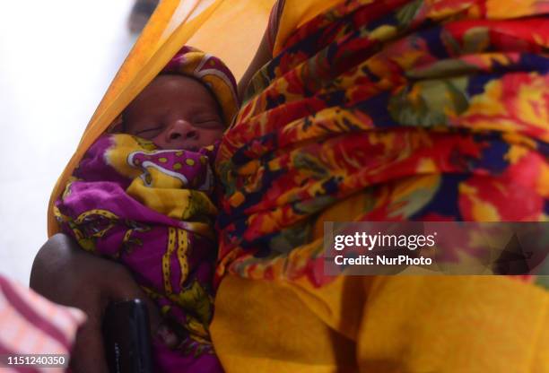 An Indian local woman of Minapur village stand in a queue with her child for checkup of symptoms of AES at community health centre , some 30 kms from...