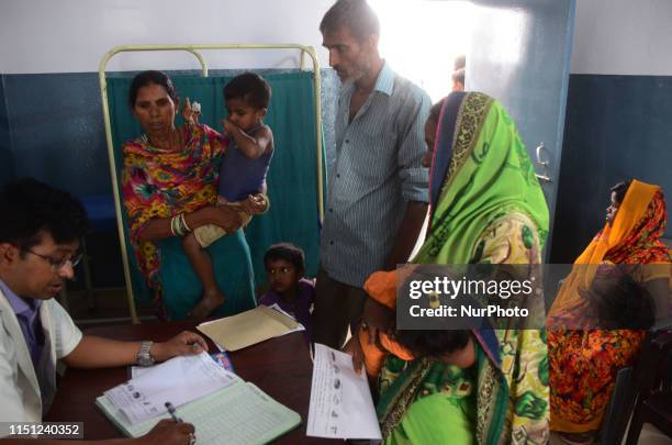 An Indian local doctor writes prescription after checkup of symptoms of AES at community health centre , in Mina pur village ,some 30 kms from...