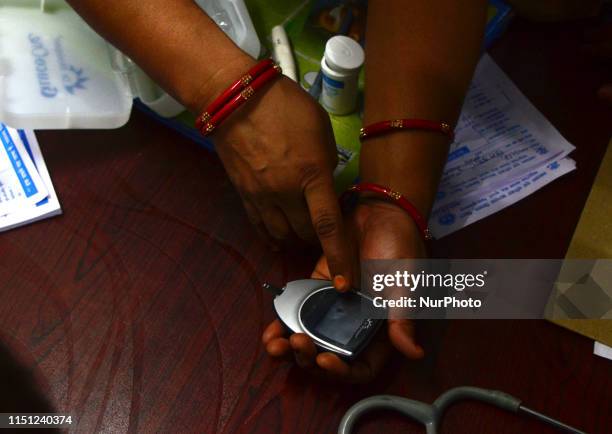 An Indian local doctor of Mushahari village demonstrate the working of glucometer machine for the patients suffering from AES , in AES ward of...