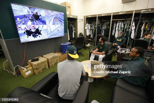 Members of the Oakland Athletics play Mario Kart in the clubhouse prior to the game against the Cincinnati Reds at the Oakland-Alameda County...