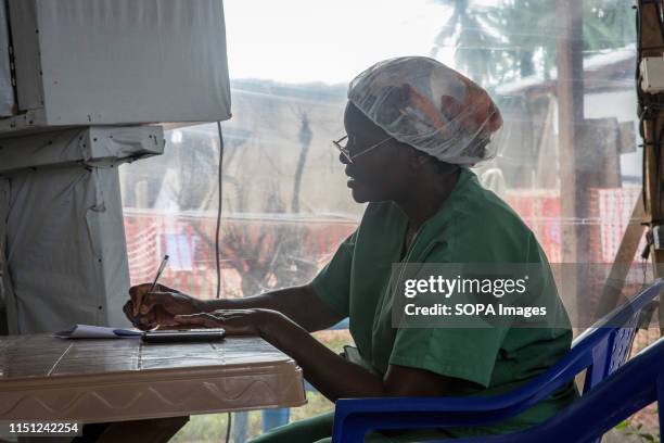 Nurse takes notes beside an isolation unit at the Ebola treatment centre in Beni, eastern Democratic Republic of the Congo. The DRC is currently...