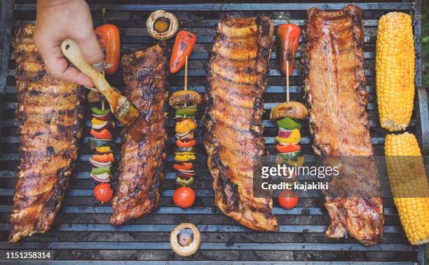 preparing pork ribs on the barbecue grill - rib food stock pictures, royalty-free photos & images