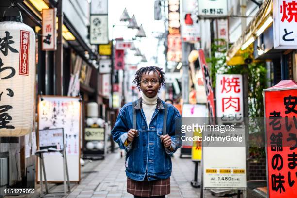 young woman standing in tokyo street with signs - gap year stock pictures, royalty-free photos & images