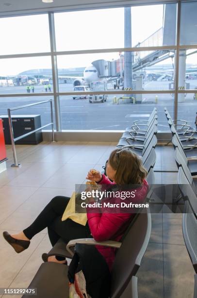 woman eating muffin at airport - prague food stock pictures, royalty-free photos & images