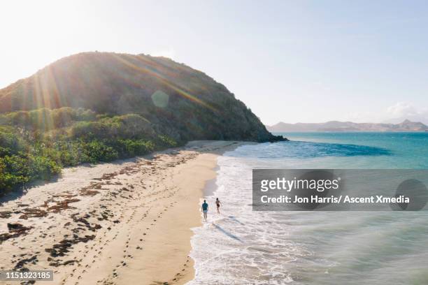 aerial view of couple walking along beach - caribbean sea life stock pictures, royalty-free photos & images