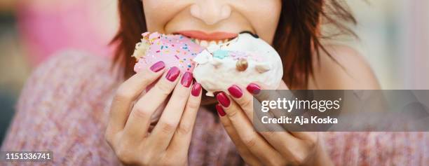 unrecognizable young woman eating delicious donuts. - over-eating stock pictures, royalty-free photos & images