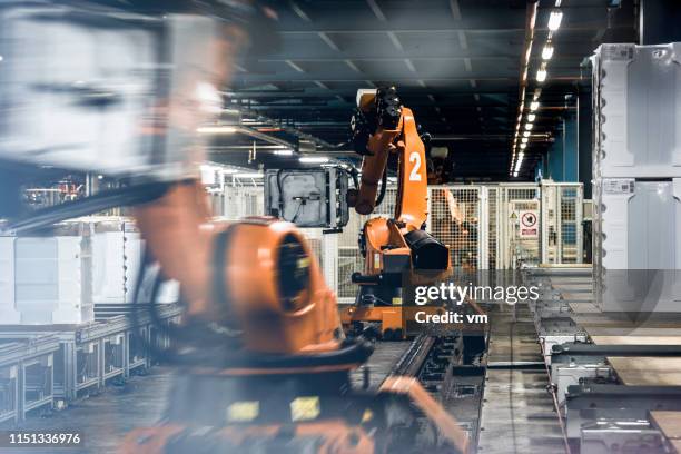 verschwommene bewegungsfoto der roboterarme in einer fabrik - automated warehouse stock-fotos und bilder