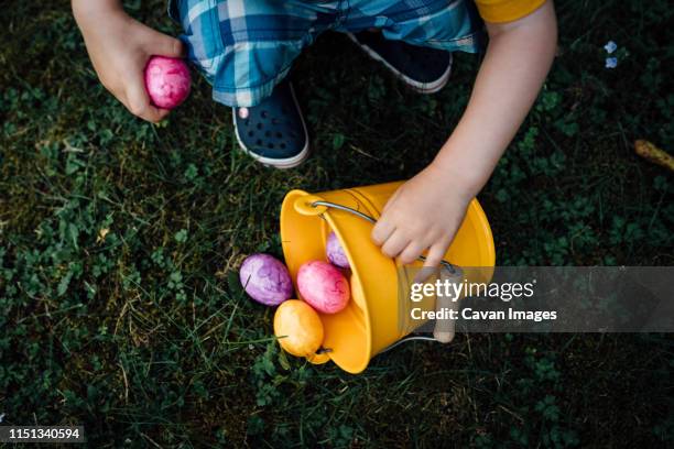 little boy finding easter eggs in spring on an egg hunt - easter egg hunt stock pictures, royalty-free photos & images