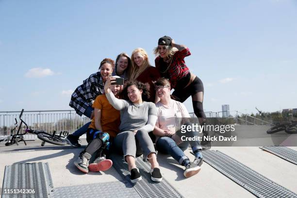portrait of young women taking selfie at skate park - olympic park venue stock-fotos und bilder