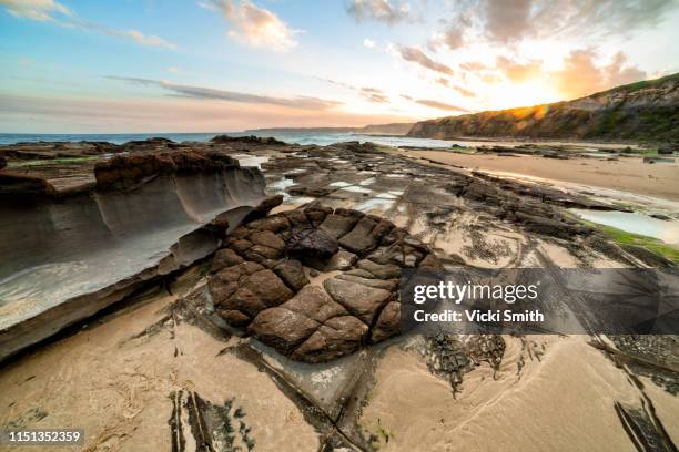 vibrant colored sunrise over the ocean with rocks - newcastle nouvelle galles du sud photos et images de collection