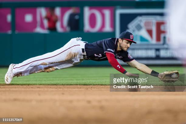 Trea Turner of the Washington Nationals dives for a ground ball against the Atlanta Braves during the fifth inning at Nationals Park on June 21, 2019...