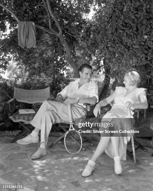 Married American actors John Gilbert and Virginia Bruce during a tennis match, circa 1933.