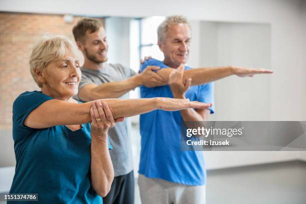 active seniors working out with trainer - sports physiotherapy stock pictures, royalty-free photos & images
