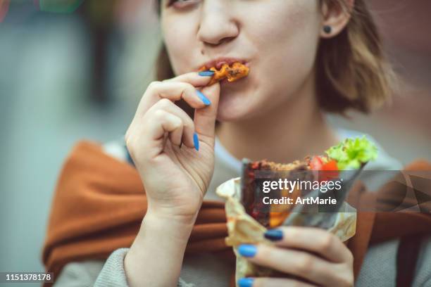 glückliches junges mädchen, das im sommer street food in der stadt genießt - shawarma stock-fotos und bilder