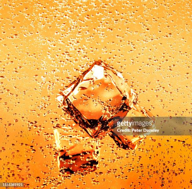 ice cubes in refreshing orange juice drink - sprudelgetränk stock-fotos und bilder