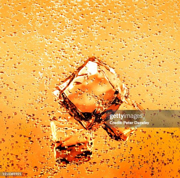 ice cubes in refreshing orange juice drink - soda stock pictures, royalty-free photos & images