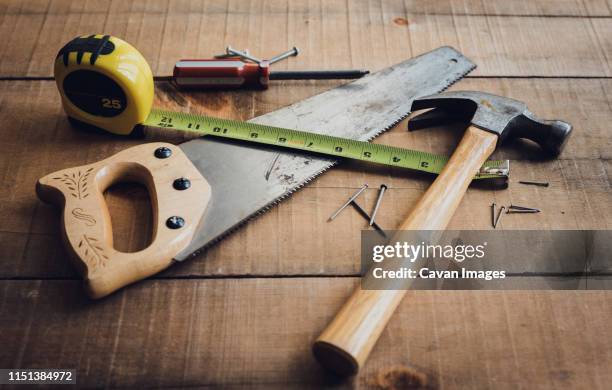 woodworking tools scattered on a wooden table. - martillo herramienta de mano fotografías e imágenes de stock