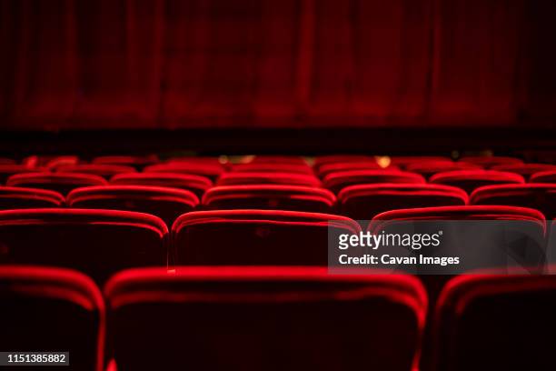 red seats and curtains of an empty theater - filmindustrie stock-fotos und bilder