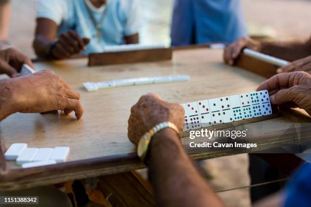 elderly gentlemen playing a game of dominoes in trinidad, cuba. 2017. - dominoes stock pictures, royalty-free photos & images