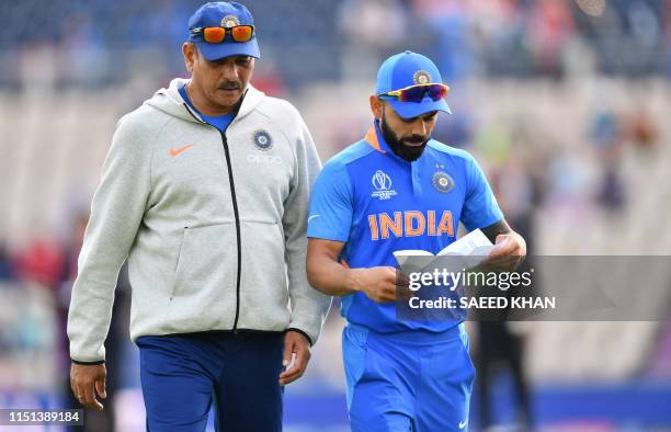 India's captain Virat Kohli speaks with India's head coach Ravi Shastri ahead of the 2019 Cricket World Cup group stage match between India and...