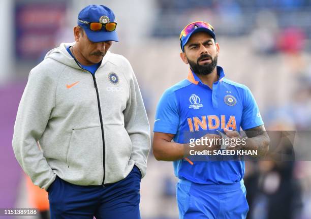 India's captain Virat Kohli speaks with India's head coach Ravi Shastri ahead of the 2019 Cricket World Cup group stage match between India and...