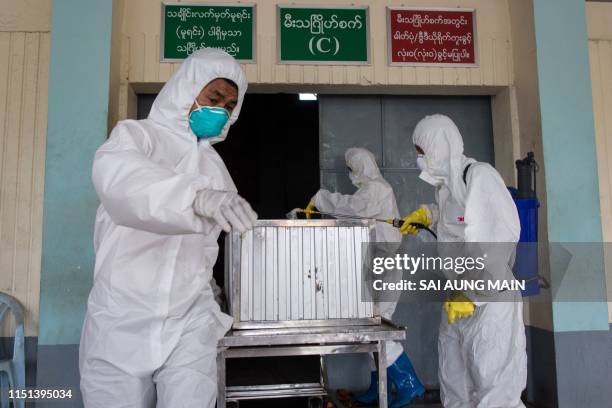 Members of a charity organisation disinfect the coffin of a person who died from the H1N1 influenza virus during a funeral service at Yay Way...