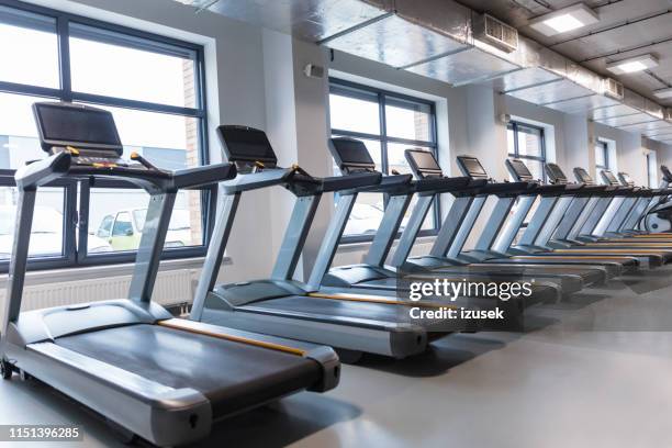 row of treadmills in a gym - exercise room stock pictures, royalty-free photos & images