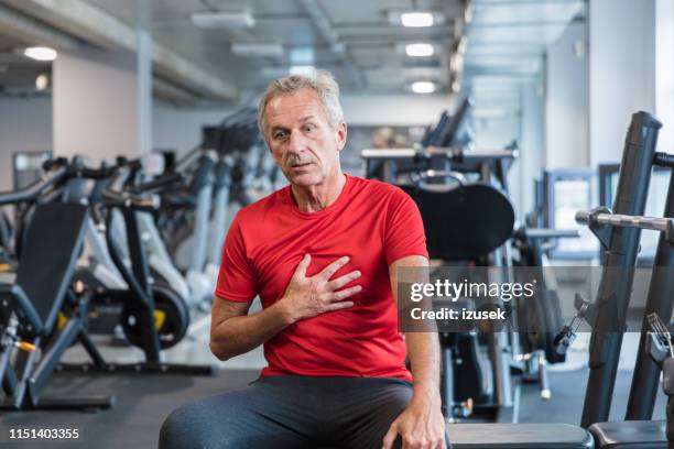 elderly man feeling chest pain at gym - breathing problems stock pictures, royalty-free photos & images