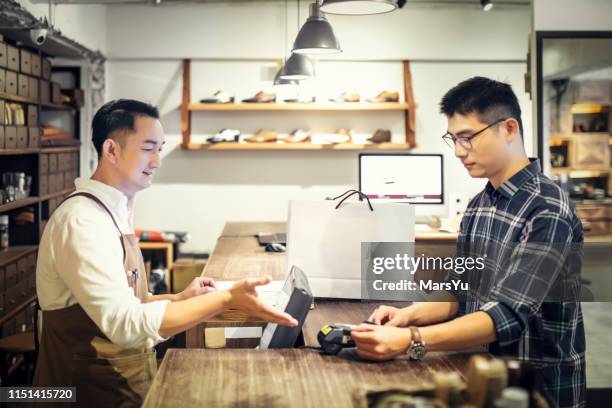 paying by credit card in the shoe store - customers pay with contactless cards stock pictures, royalty-free photos & images