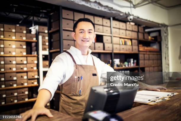 portrait of cheerful man at the cash desk - shoe shop assistant stock pictures, royalty-free photos & images