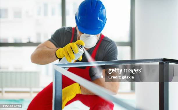 spray painting a metal table frame. - aerosol can stock pictures, royalty-free photos & images