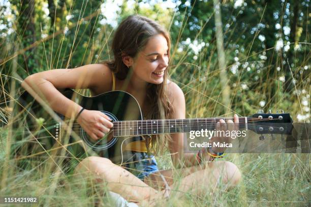 menina adolescente que joga a guitarra - dedilhar instrumento - fotografias e filmes do acervo
