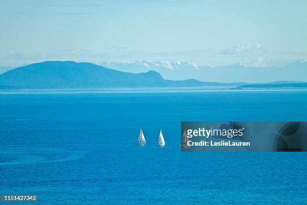 sailboats in ocean with mountains in background - sailboat painting stock pictures, royalty-free photos & images