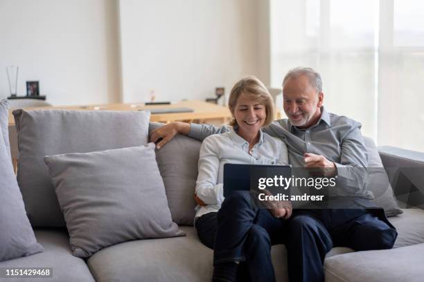 senior couple at home going online on a digital tablet - diabetic amputation stock pictures, royalty-free photos & images