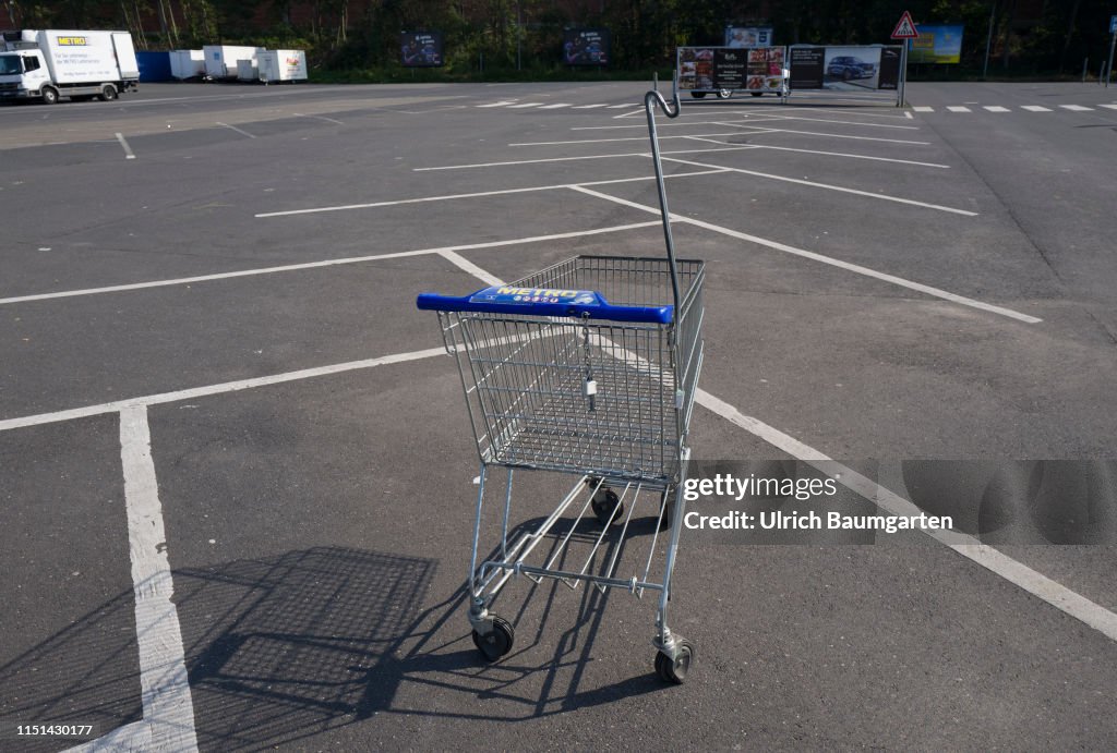 Takeover speculations - the Metro AG in trouble. The empty parking lot and a single shopping cart of a branch of Metro AG in St. Augustin, during the normal opneng hours.
