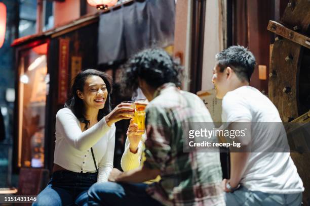 group of friends enjoying japanese style pub - tokyo japan night alley stock pictures, royalty-free photos & images